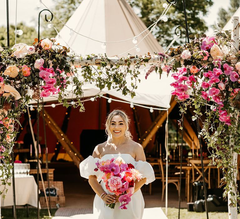 Bride in off the shoulder wedding dress with pink wedding bouquet 