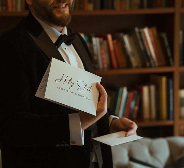 Groom in black tuxedo reading letter from the bride on the morning of the wedding 