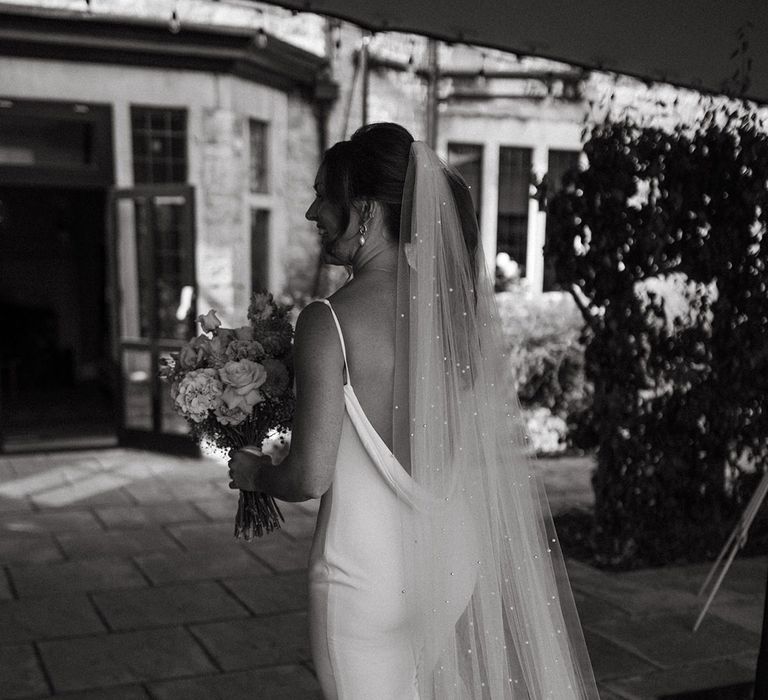 Bride wearing delicate pearl veil and open back satin gown by Made With Love 