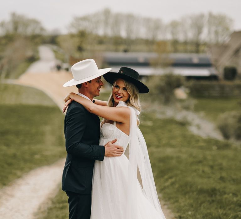 Bride and groom share an embrace together at their country western theme wedding 