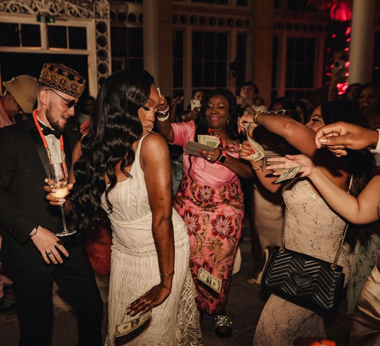 The bride and groom participate in the Nigerian money dance 