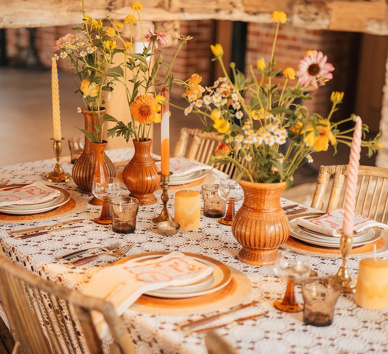 Retro orange wedding inspiration using patterned and textured candles, orange and yellow wedding flowers and more 