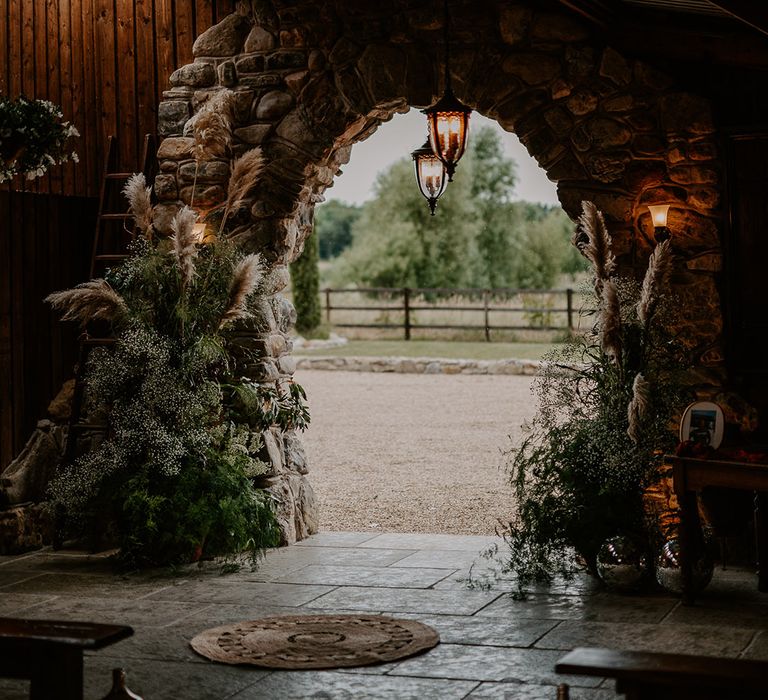 Pampas grass and gypsophila flower column arrangements decorating the Willow Marsh Farm wedding venue 