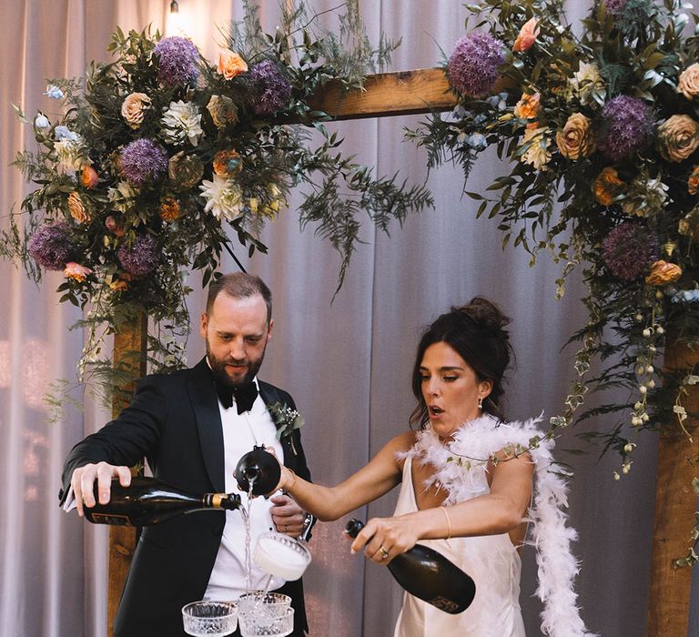 Champagne tower wedding decoration that topples over as the bride and groom pour in champagne 