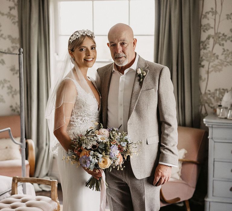 Elmley Nature Reserve wedding venue with the bride in a lace wedding dress posing with the father of the bride 