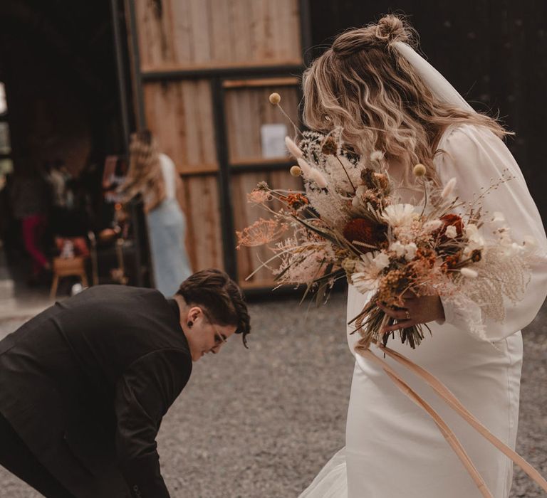 Bride helps the bride with her wedding dress 