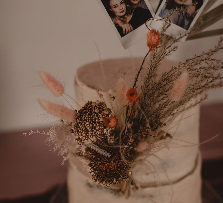 Two tier rustic semi-naked wedding cake with dried flower decorations 