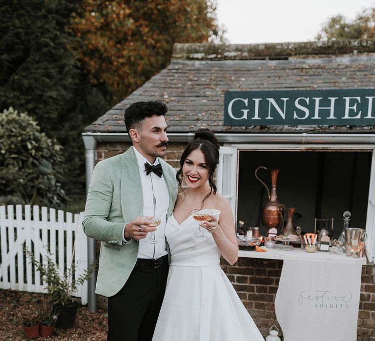 Bride embracing groom in green suit for green christmas theme wedding 