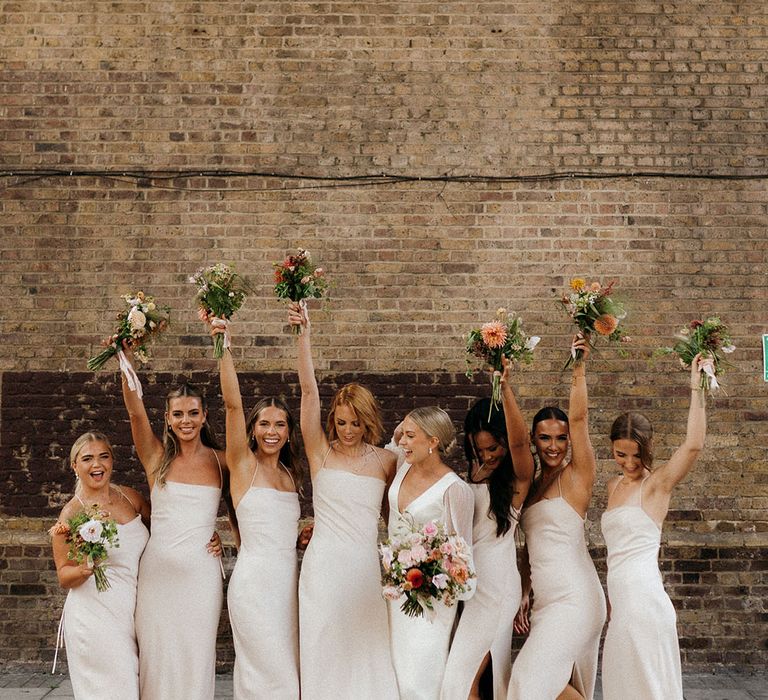 Bridal party wearing neutral bridesmaid dresses from Meshki with bride 