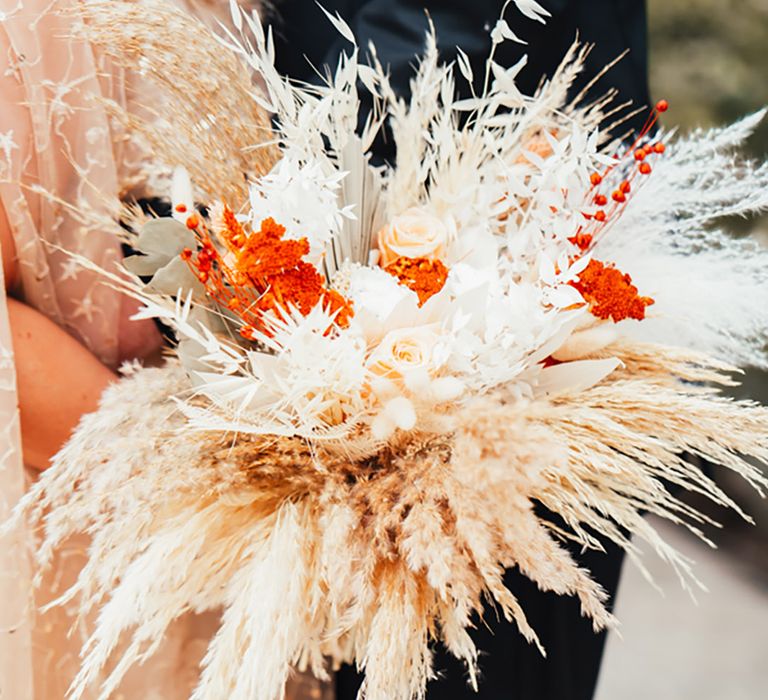 Bride holding a pampas grass wedding bouquet with dried wedding flowers 