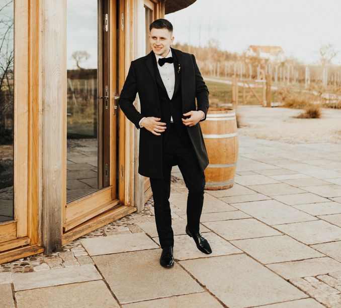 Groom getting ready outside Picturesque Brickhouse Vineyard 