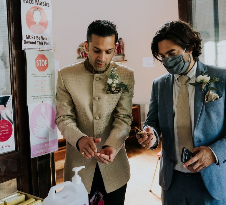 groom and best man sanitising their hands at 2020 wedding