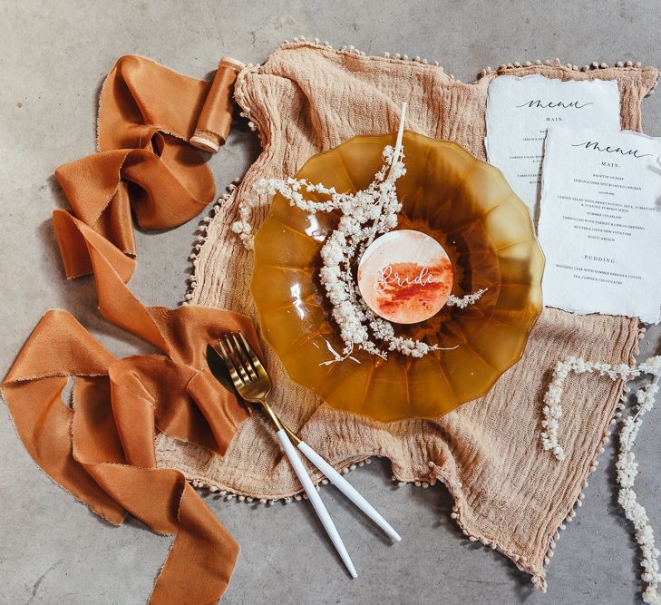 place setting with coloured tableware and linens 