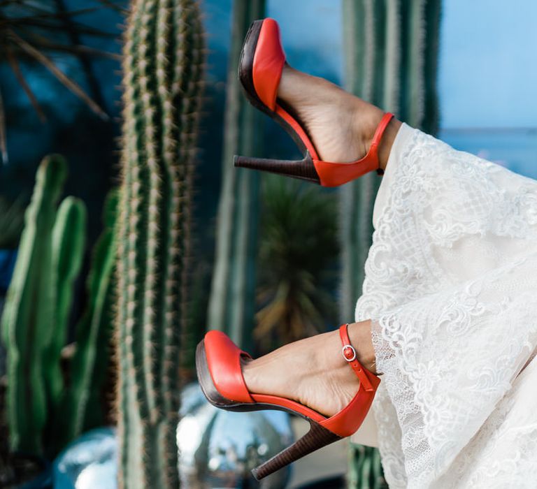 Bride's legs in White Lillian West bridal jumpsuit and red heels from Next 