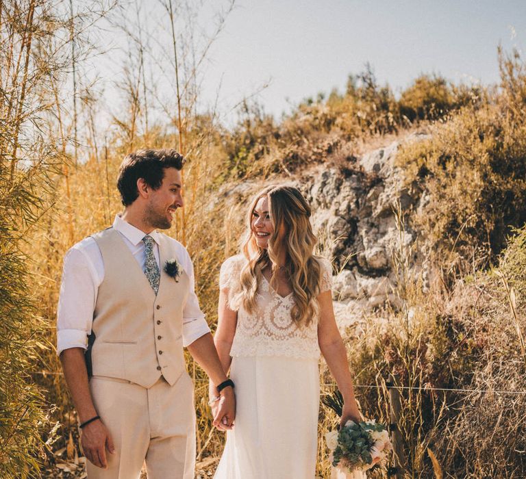 The bride and groom walk through the grounds of Le Mas De La Rose