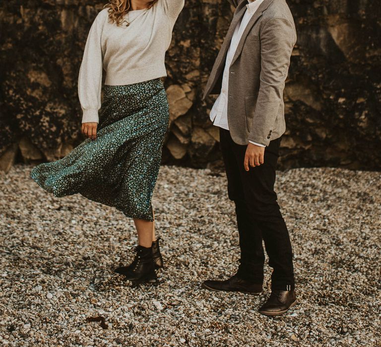 Couple dance on beach for engagement shoot