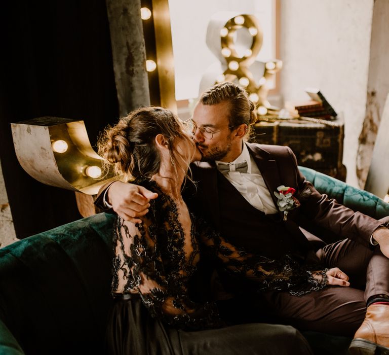 Bride and groom kissing on a sofa 