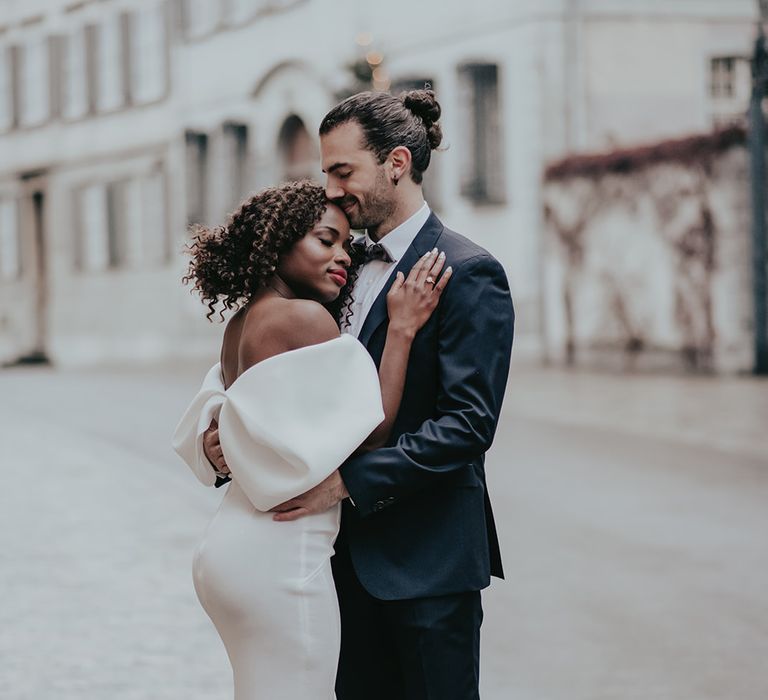 Bride & groom embrace outdoors on the streets