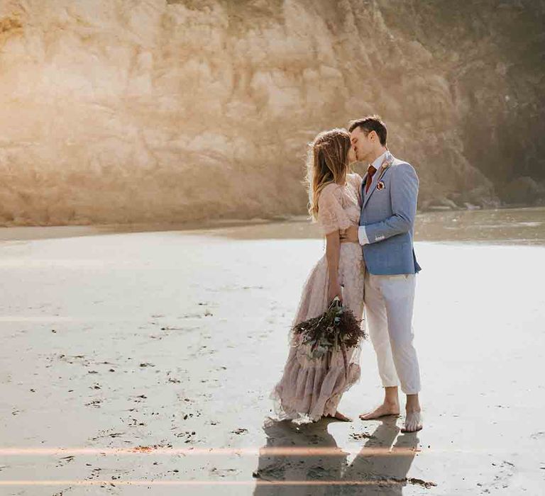 Bride and groom barefoot in the sand at Lusty Glaze wedding