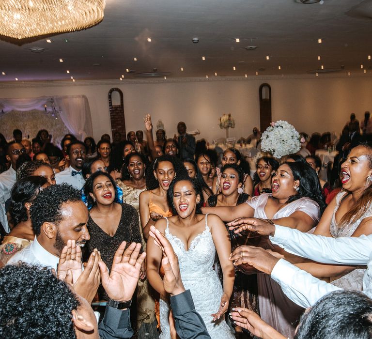 Ethiopian bride in a lace wedding dress with thin straps on the dance floor 