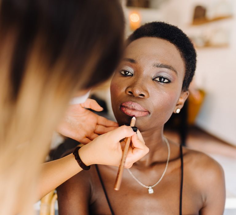 Bride has her lipstick applied on the morning of her wedding