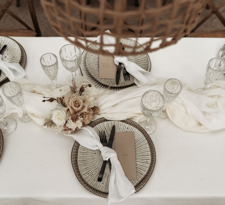 Place settings with neutral tableware and black cutlery 