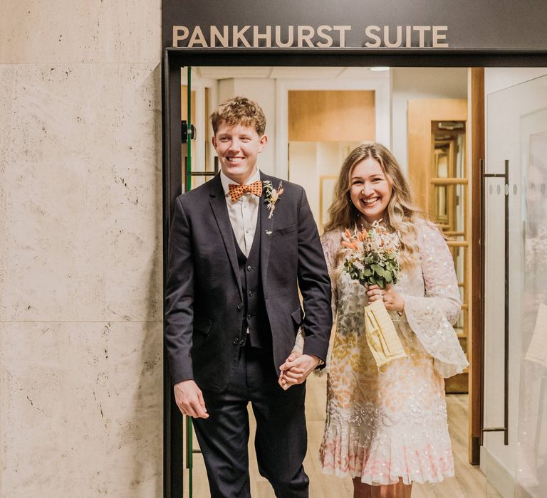 Bride and groom walking out of wedding venue in Manchester 