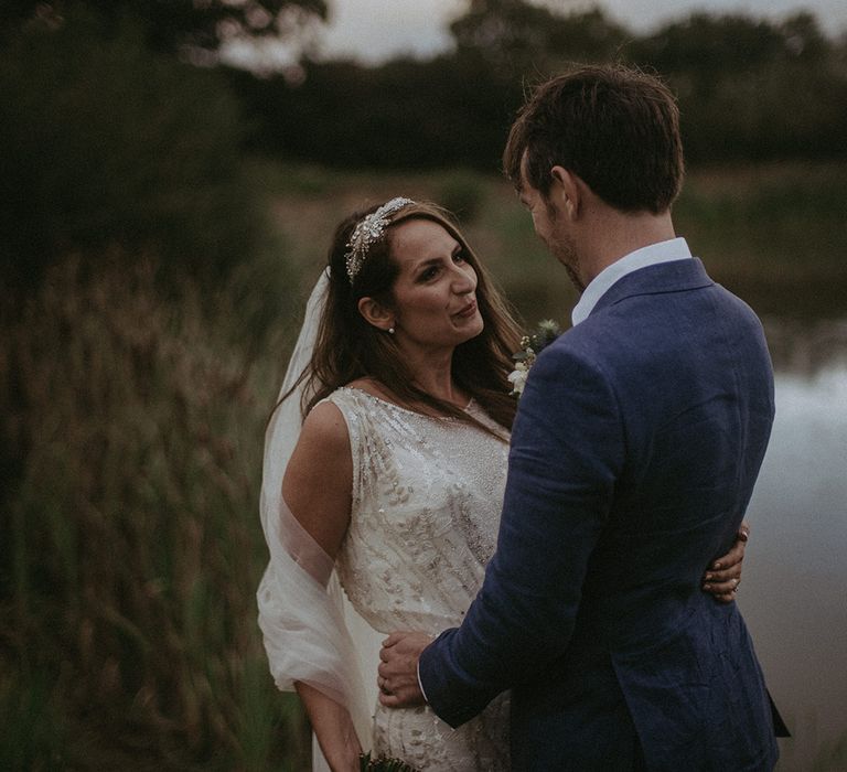 Bride looks lovingly at groom outdoors on their wedding day