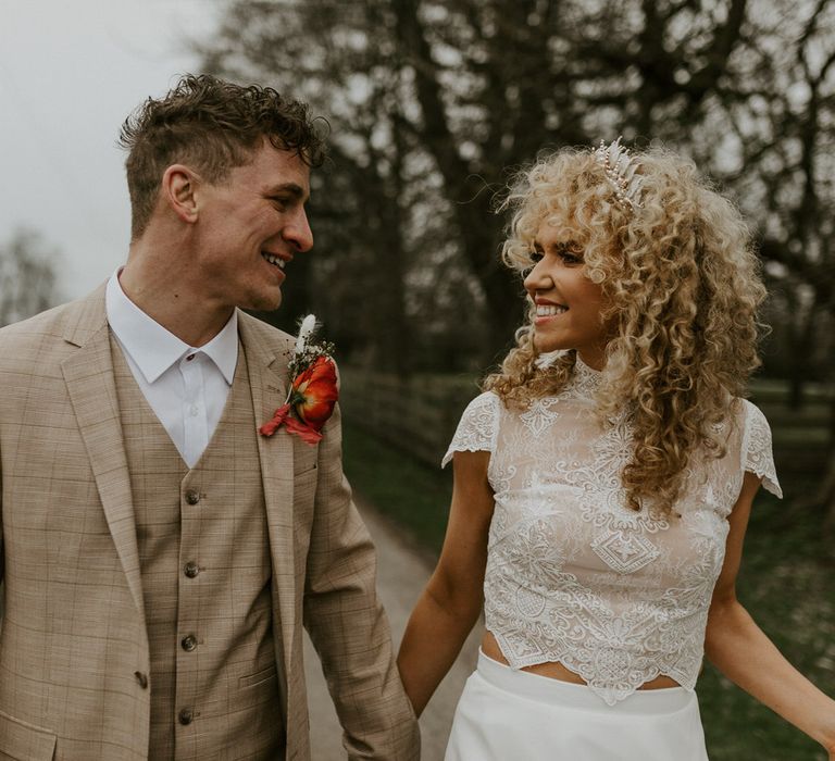 Bride and groom in the countryside at Hornington Manor, the bride is wearing a tiara in her curly blonde wedding hair