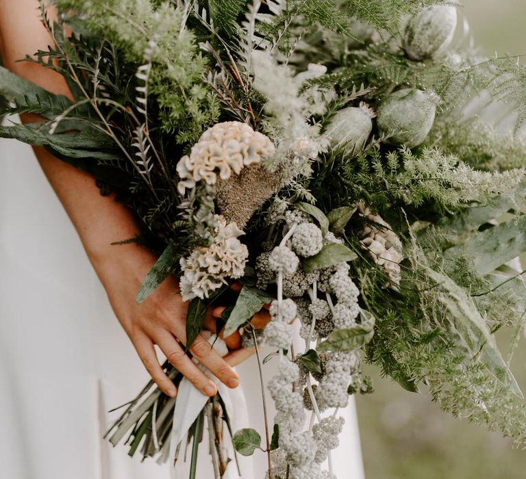 Tropical green wedding bouquet with ferns, dried poppy heads and celosias