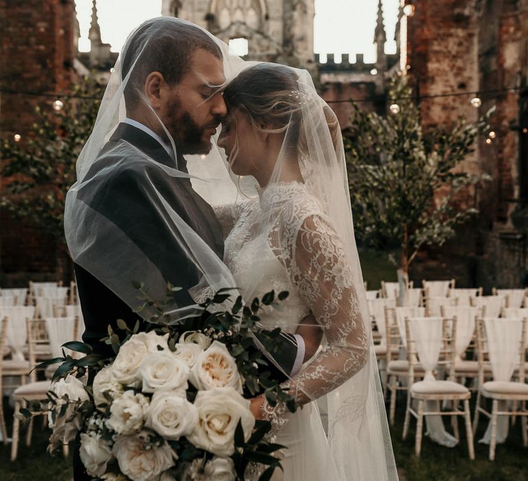 Intimate bride and groom portrait at St Luke's in Liverpool with festoon lights and tree decoration 