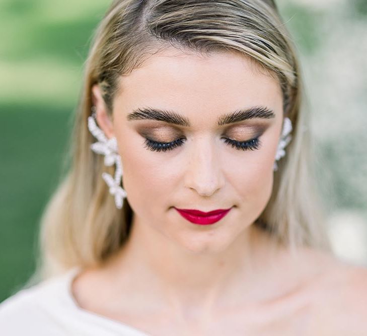 Bronze smokey eye makeup, defined eyebrows and red lipstick for stylish bride 