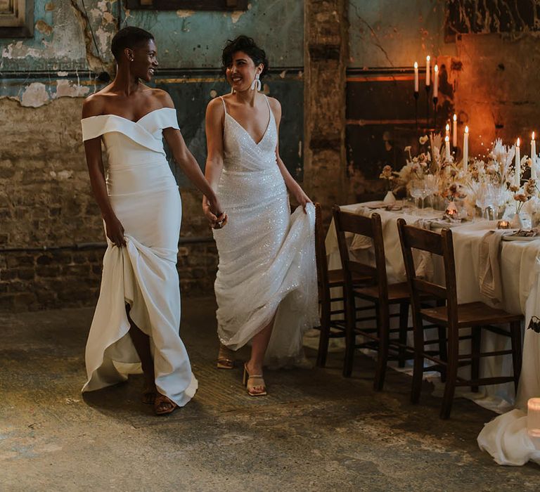 LGBTQI+ couple holding hands standing next to their intimate wedding reception table at The Asylum wedding venue 