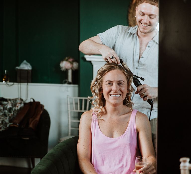 Bride has her hair done on the morning of her wedding day