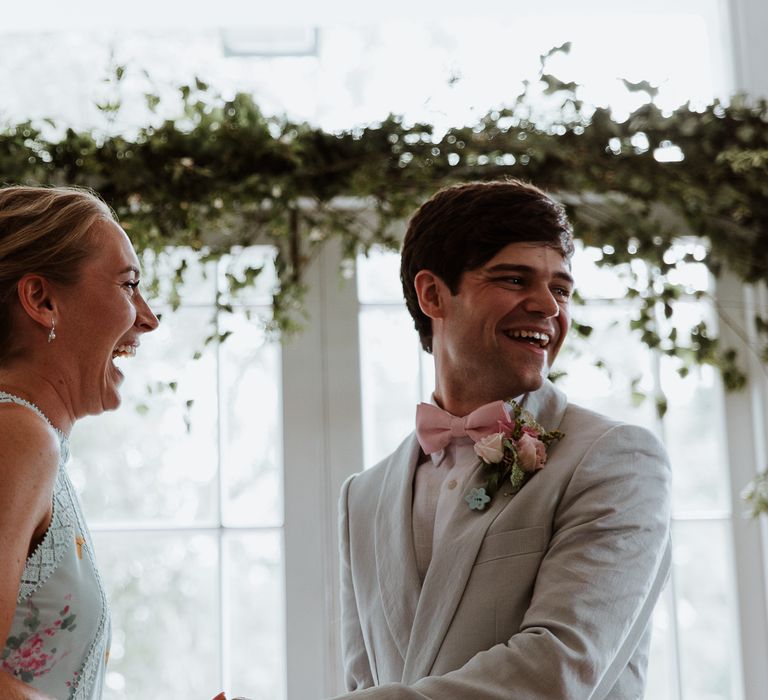 Bride & groom laugh with one another during wedding ceremony