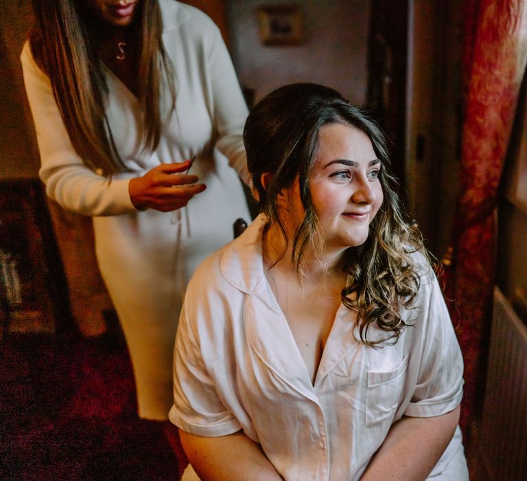 Bride has her dark hair curled on the morning of her wedding day