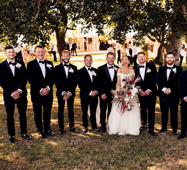 Bride with groomsmen at black tie wedding