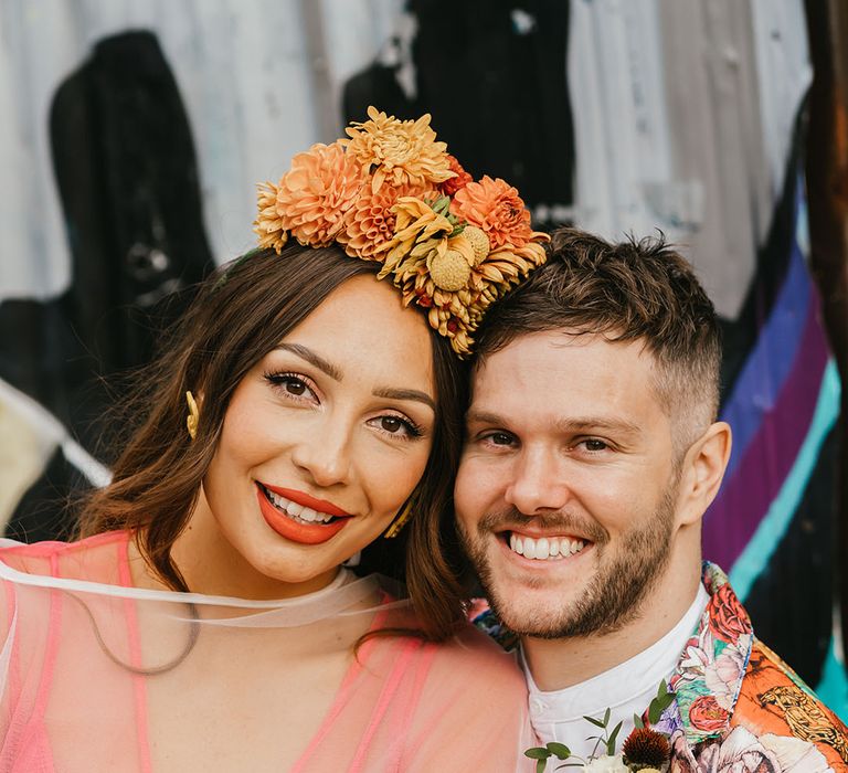 Intimate bride and groom portrait with bride in a Frida Kahlo flower crown and red lipstick and groom in a patterned jacket 