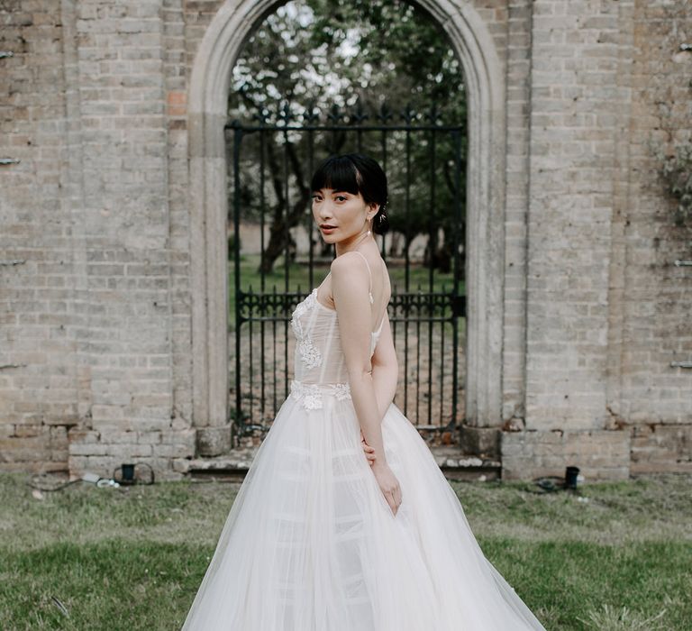 South Asian bride with a blunt fringe in a princess wedding dress with tulle skirt and fitted bodice 