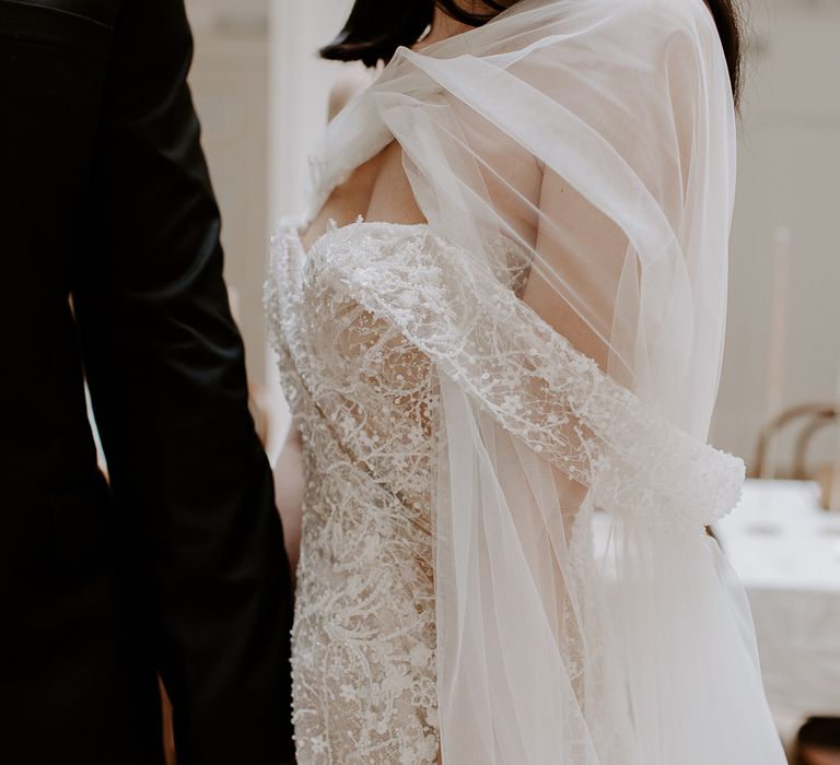 delicate lace and embellished off the shoulder wedding dress detail 