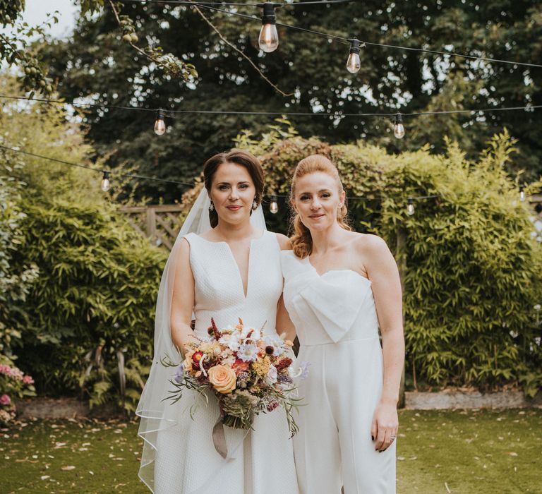 Bride with bridesmaid in jumpsuit