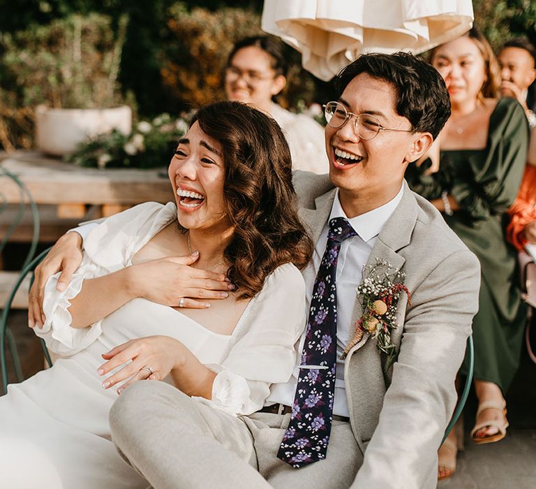 Bride & groom laugh outdoors on their wedding day