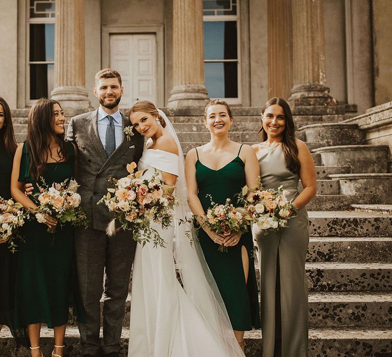 Bride & groom stand with bridesmaids on their wedding day 