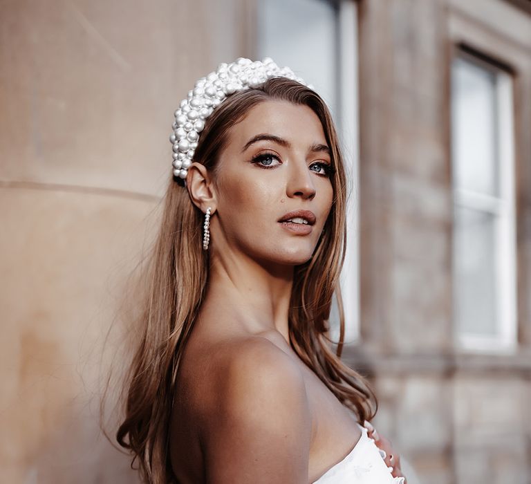 Bride with natural wedding makeup and a pearl headband in an off the shoulder wedding dress