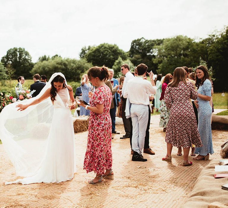 Bride moves her veil on her wedding day outdoors