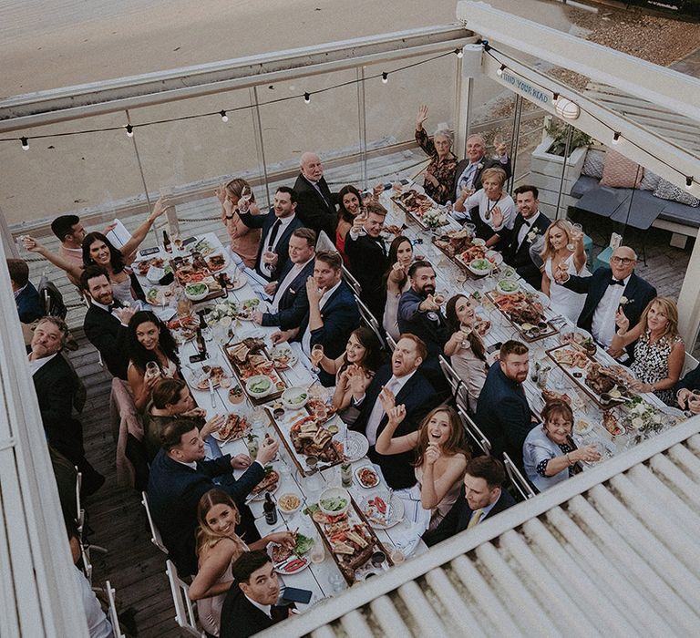 Wedding guests wave at Isle of Wight wedding photographer