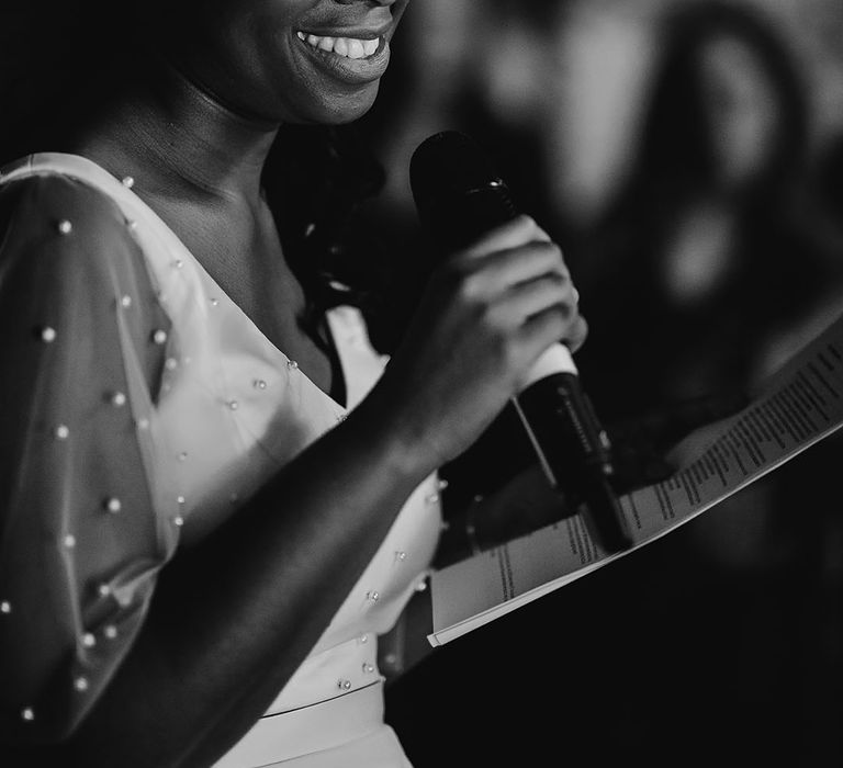 Black bride in a pearl top giving her brides' wedding speech 