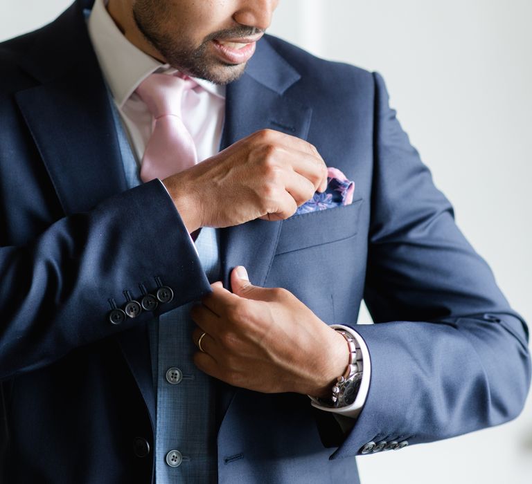 Groom places pocket square on the morning of his wedding day