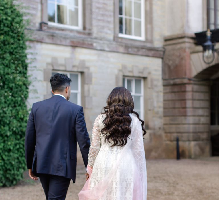 Bride & groom walk with one another outdoors at Ragley Hall