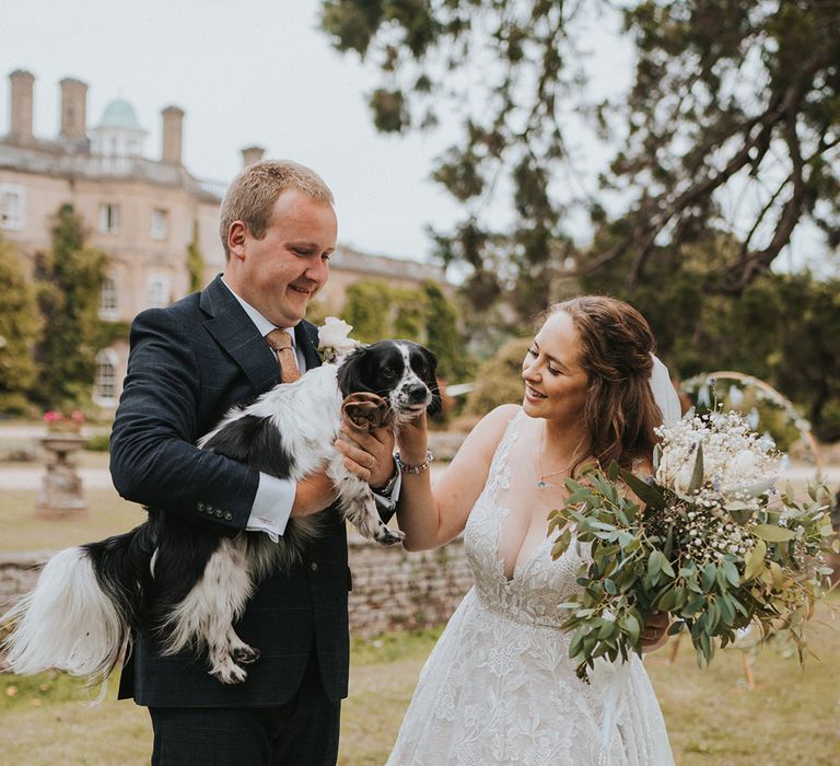 Bride and groom pose with their pet dog after their wedding ceremony 